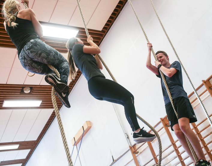 Elever klatrer i tau