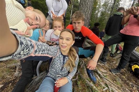 en gruppe mennesker som sitter på bakken utenfor