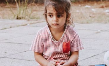 et barn som sitter på bakken