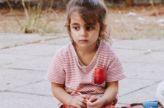 et barn som sitter på bakken