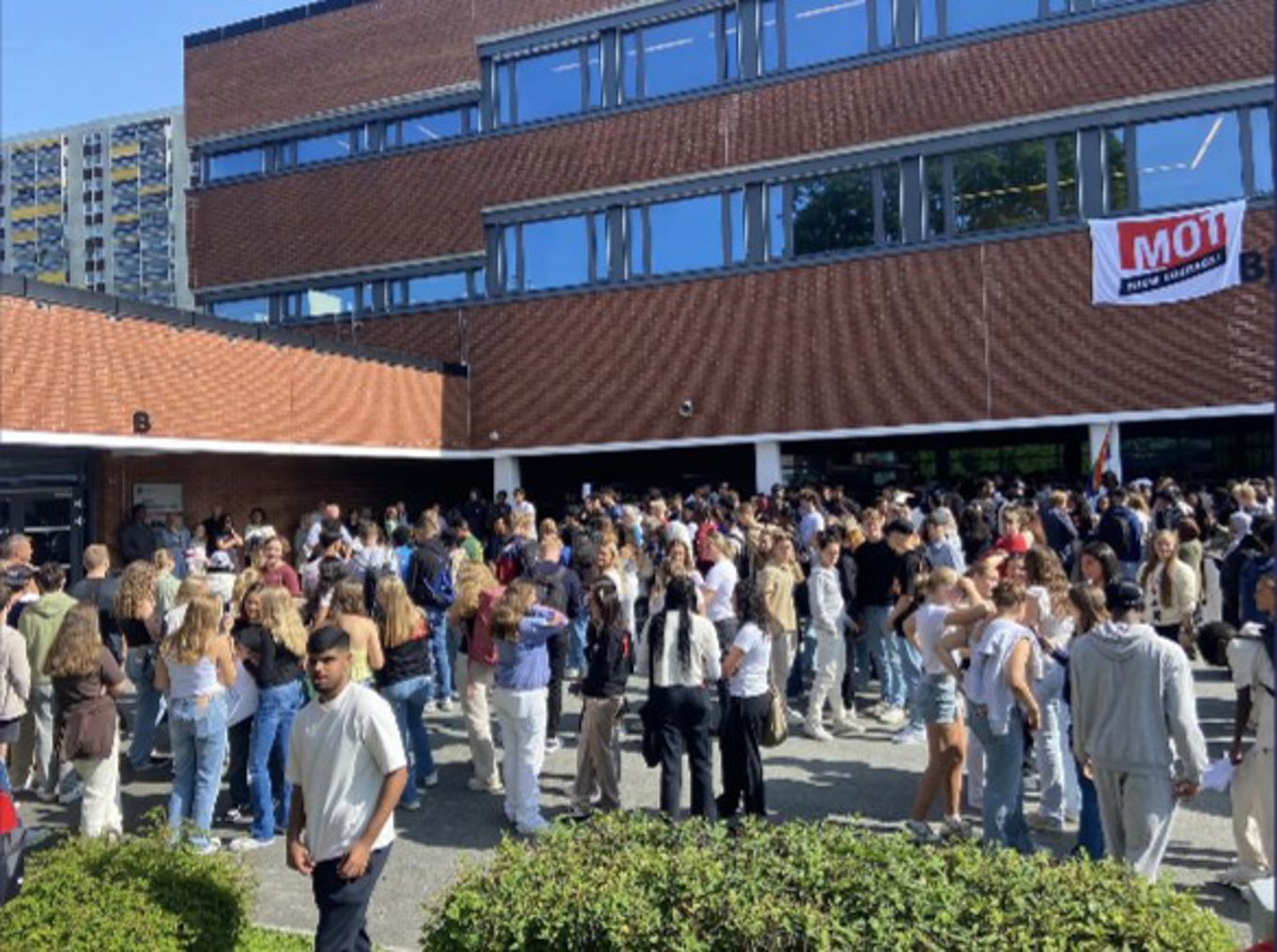 en stor gruppe mennesker står utenfor en bygning
