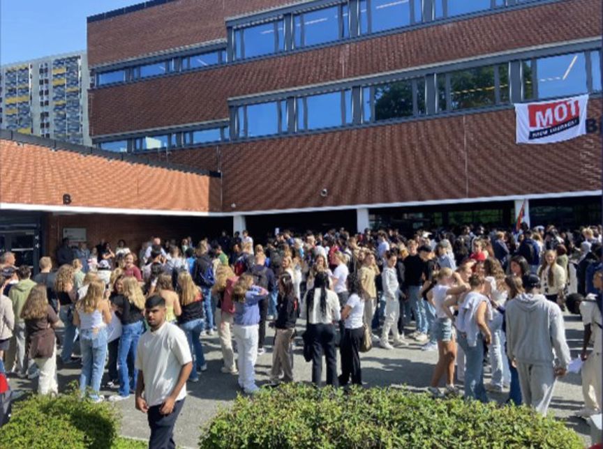 en stor gruppe mennesker står utenfor en bygning